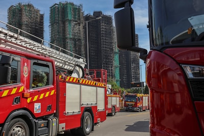 a-fire-truck-drives-past-fire-damaged-residential-blocks-at-the-wang-fuk-court-housing-complex-follo.jpeg