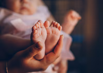a-tender-close-up-shot-captures-the-tiny-feet-of-a-newborn-baby-radiating-warmth-and-innocence-the-g.avif