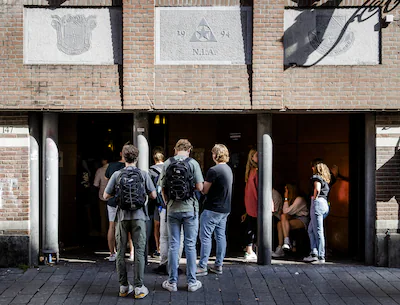 amsterdam-wachtende-mensen-bij-het-pand-van-het-amsterdamsch-studenten-corps-nieuwe-leden-kunnen-zic.webp