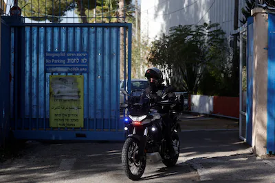 an-israeli-police-officer-rides-a-bike-while-leaving-the-united-nations-relief-and-works-agency-for.webp