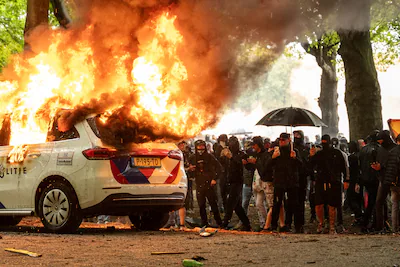 den-haag-een-politiewagen-staat-in-de-brand-tijdens-protest-tegen-het-huidige-asielbeleid-op-het-mal.webp