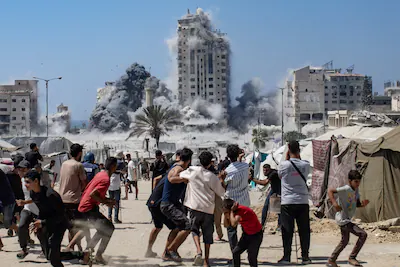 epa12569289-palestinians-react-as-smoke-rises-from-the-mushtaha-tower-following-an-israeli-airstrike.webp