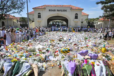 epa12606255-mourners-place-flowers-at-a-memorial-at-bondi-beach-in-sydney-australia-21-december-2025.webp