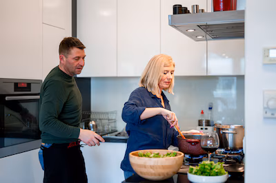 mature-couple-cooking-togehter-in-a-domestic-kitchen.avif