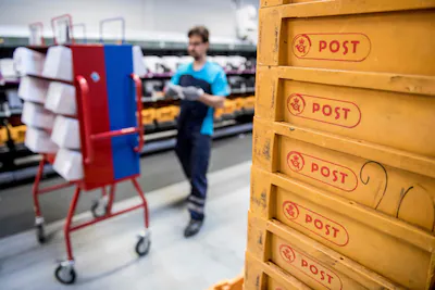 picture-taken-on-may-23-2019-shows-an-employee-of-danish-postal-service-postnord-working-at-the-comp.webp