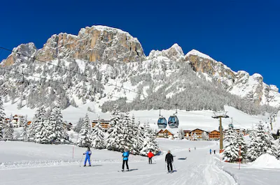 skiers-on-the-way-down-to-the-valley-station-of-the-colfosco-cable-car-colfosco-corvara-alta-badia-w.webp