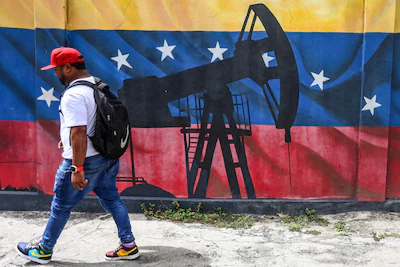 a-man-walks-past-a-mural-depicting-an-oil-pumpjack-on-a-venezuelan-flag-in-caracas-on-january-15-202.webp