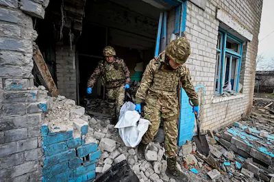 editors-note-graphic-content-topshot-ukrainian-servicemen-carry-a-plastic-bag-containing-the-body-of.webp