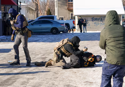 epa12678554-federal-officers-tackle-a-protester-as-they-confront-police-following-a-fatal-shooting-i.avif