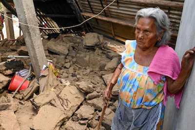 nicolasa-salgado-stands-next-to-a-damaged-house-after-the-earthquake-in-the-community-of-san-marcos.webp