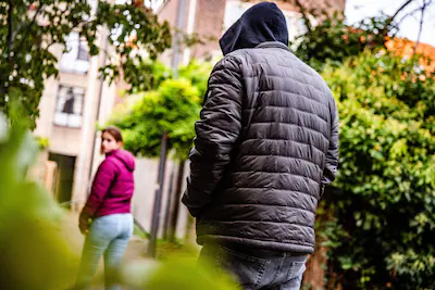 nlbeeld-jg20250929-005-illustratief-een-meisje-wordt-gevolgd-door-een-man-op-straat-in-een-stad-stra.webp