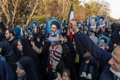 tehran-iran-january-12-people-hold-placards-and-wave-flags-during-a-pro-government-demonstration-on.jpeg