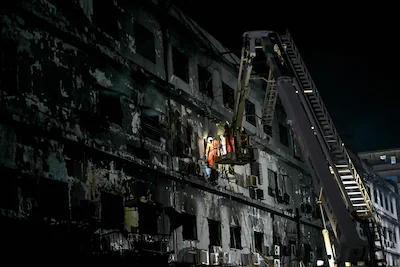 topshot-rescue-workers-search-for-bodies-among-the-rubble-after-a-massive-fire-broke-out-at-a-shoppi.webp