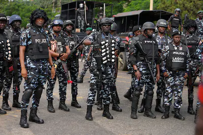 file-nigeria-police-officers-stand-guard-during-a-candle-light-procession-in-honour-of-all-protester.webp